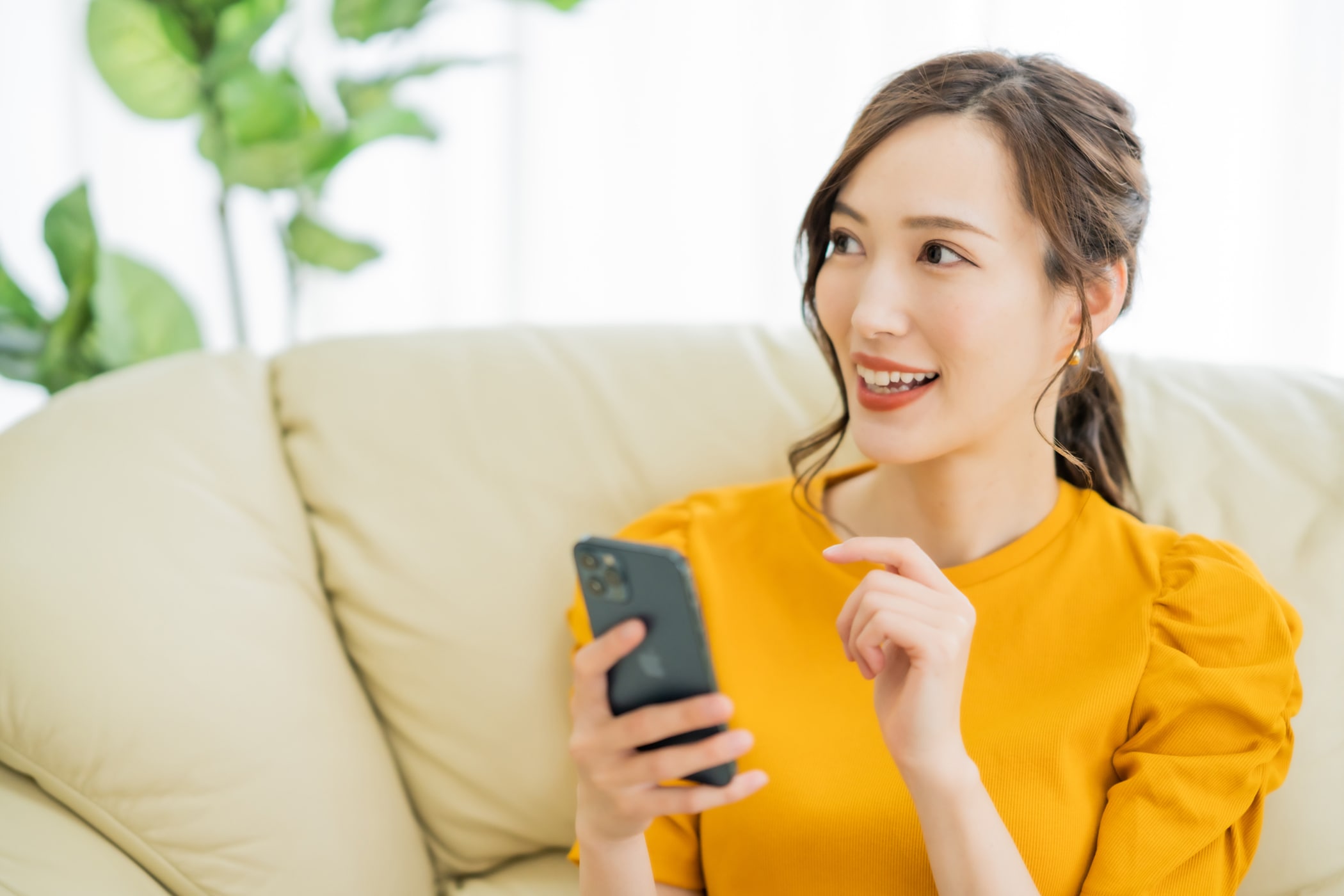 スマートフォンを持つ笑顔の女性