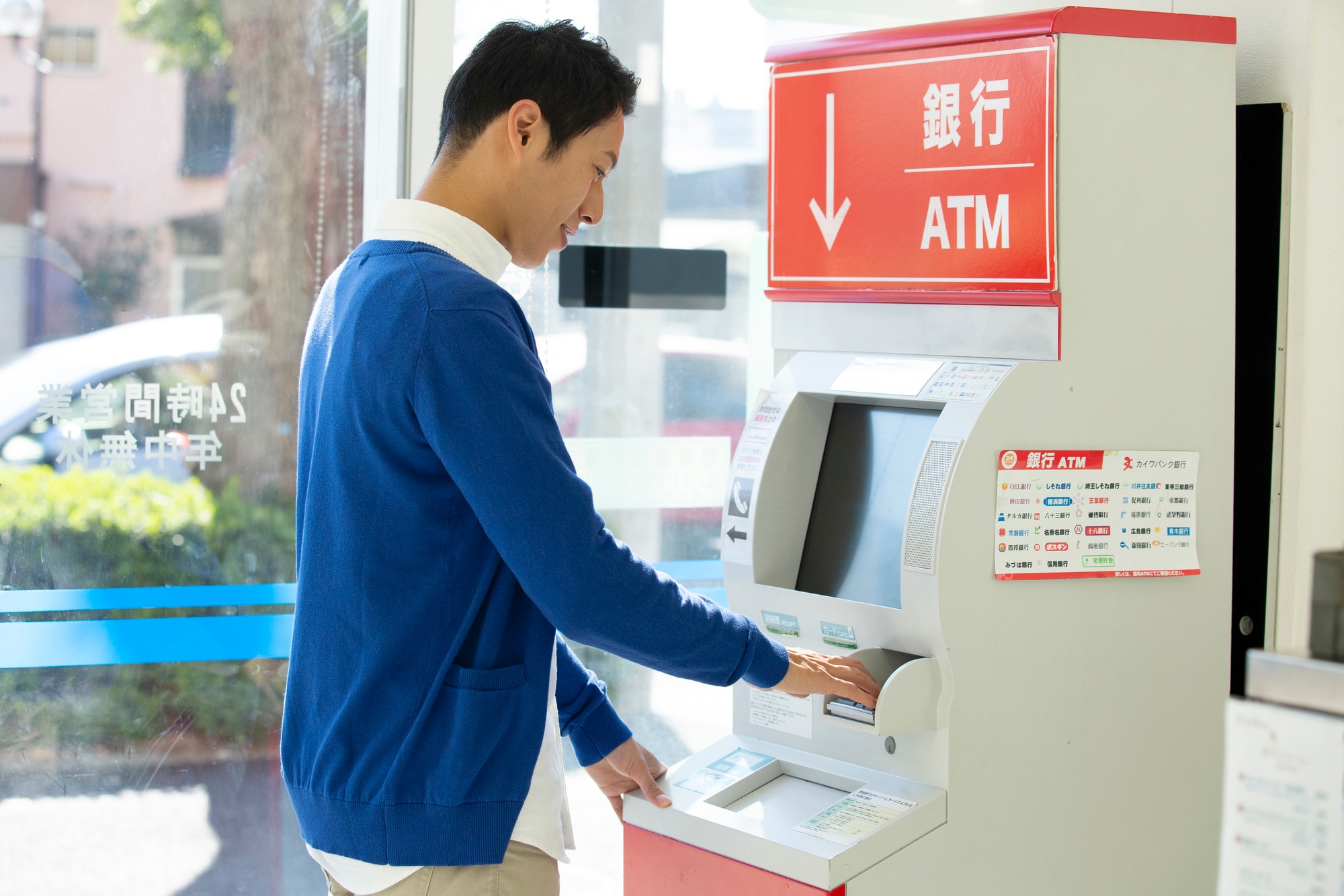 コンビニでATMを操作する男性