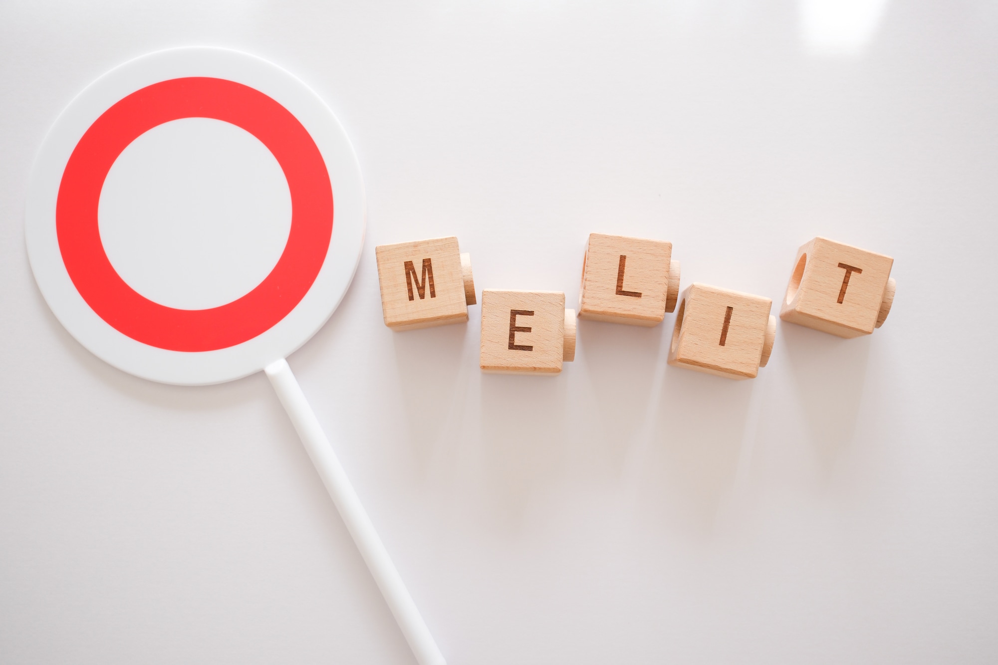 メリットと書かれた積み木と〇の札