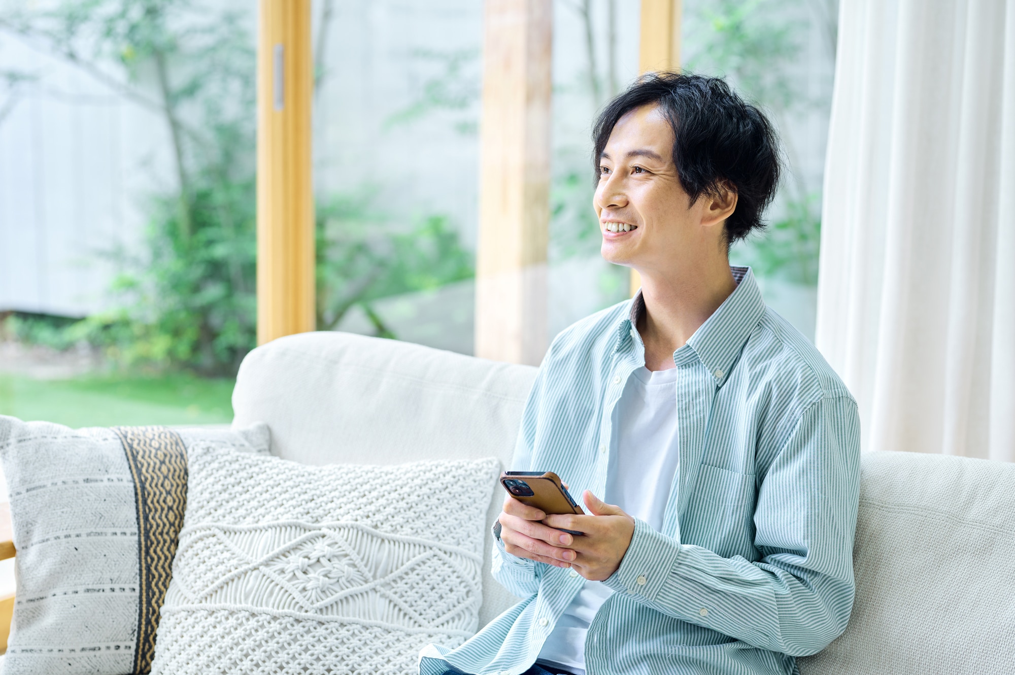 リビングでスマホを操作する男性