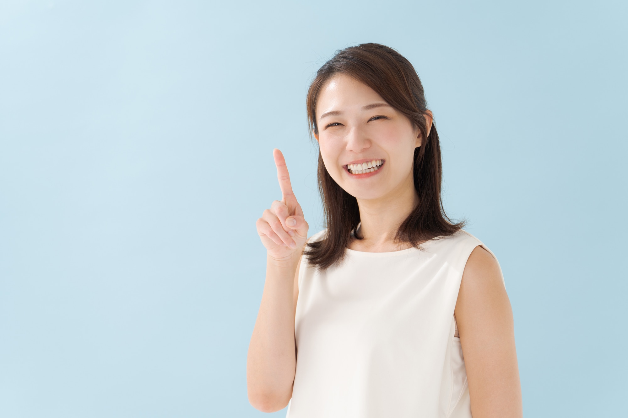 人差し指を立てて笑顔な女性