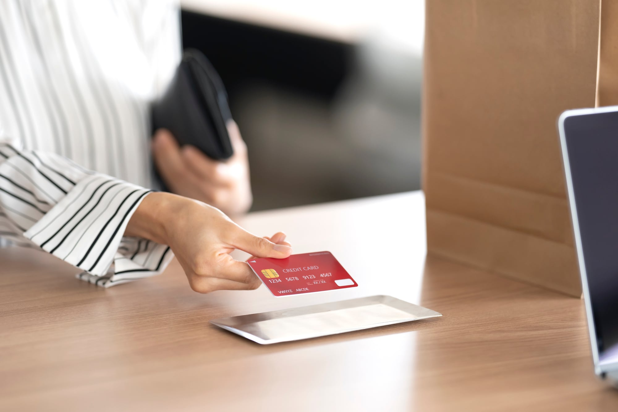 クレジットカードで支払いをする女性の手元