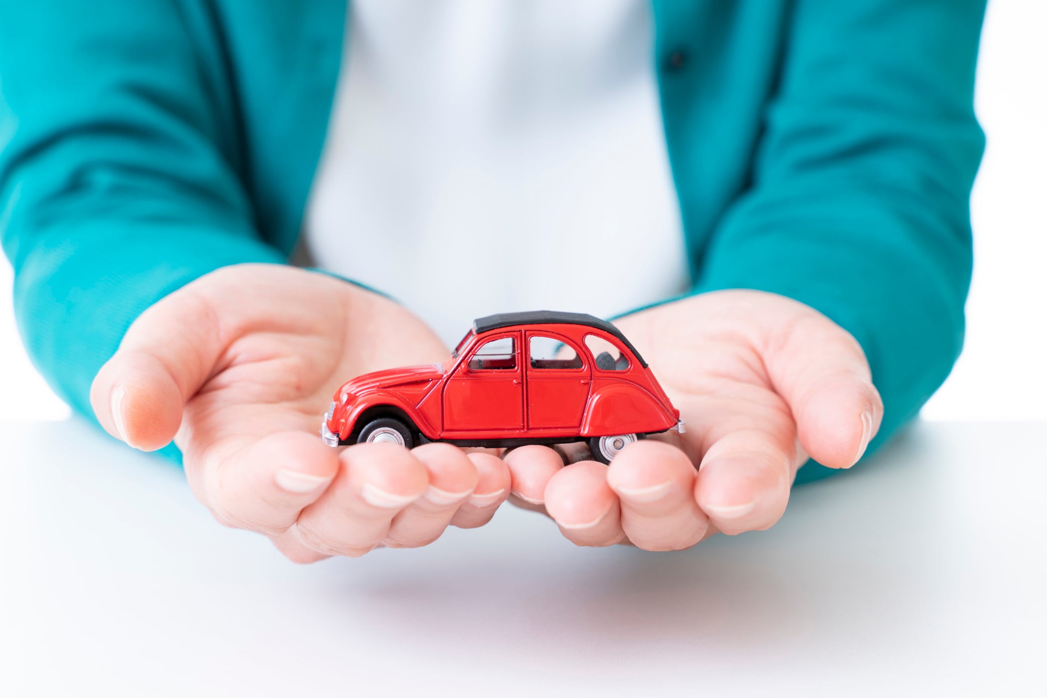 自動車の玩具を両手で持つ人