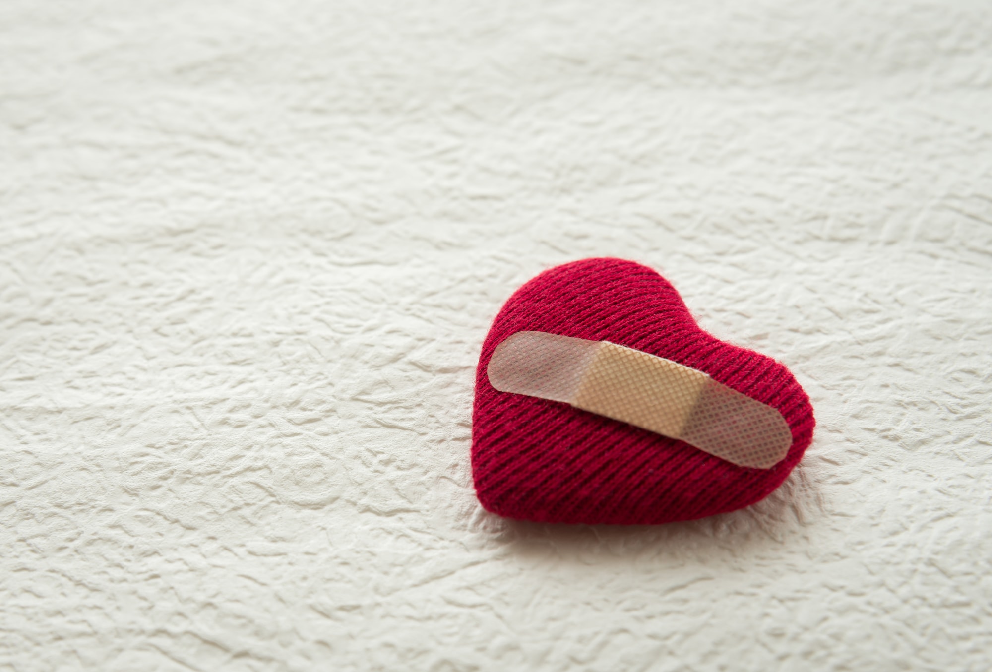 絆創膏を貼られたハートのぬいぐるみ