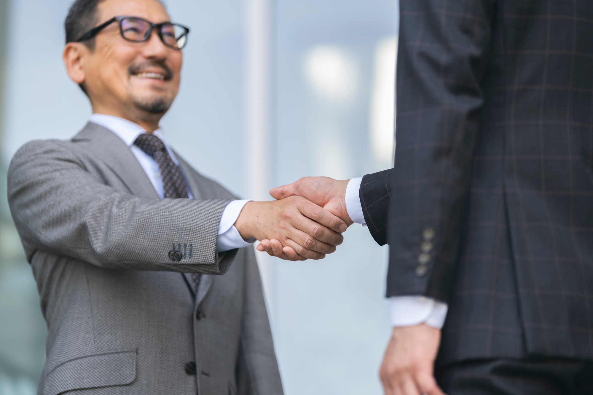 笑顔で握手を交わすジネスパーソン