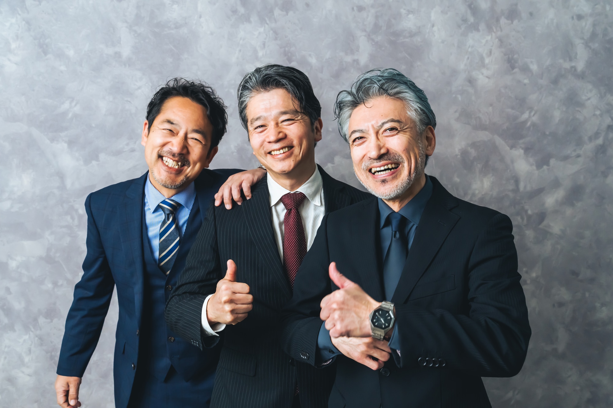 笑顔で親指を立てるジェスチャーをするミドルエイジ男性3人