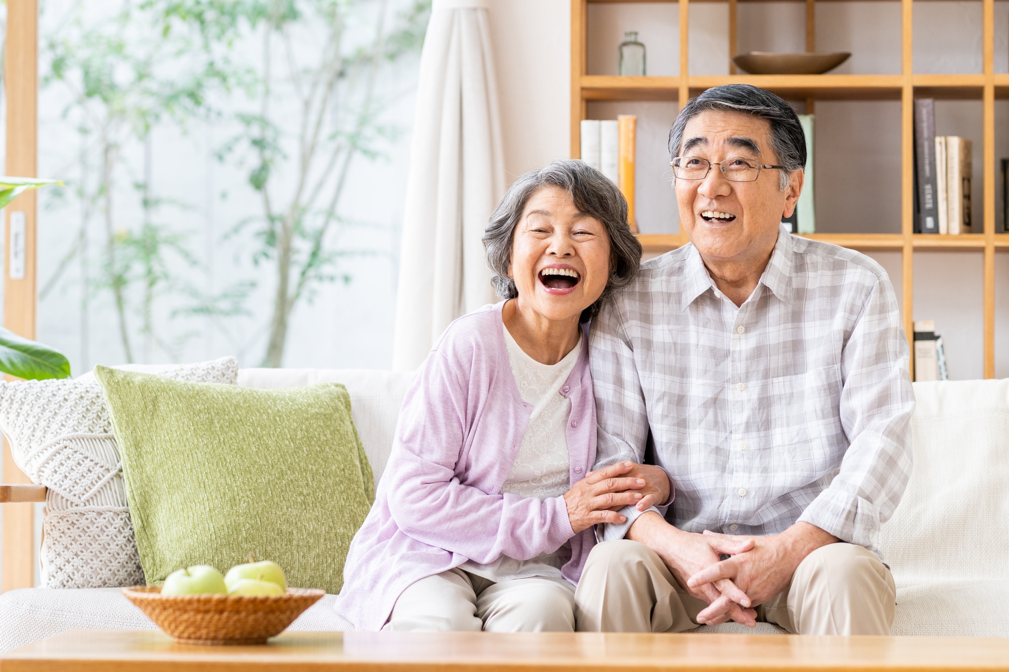 リビングで笑顔なシニア夫婦
