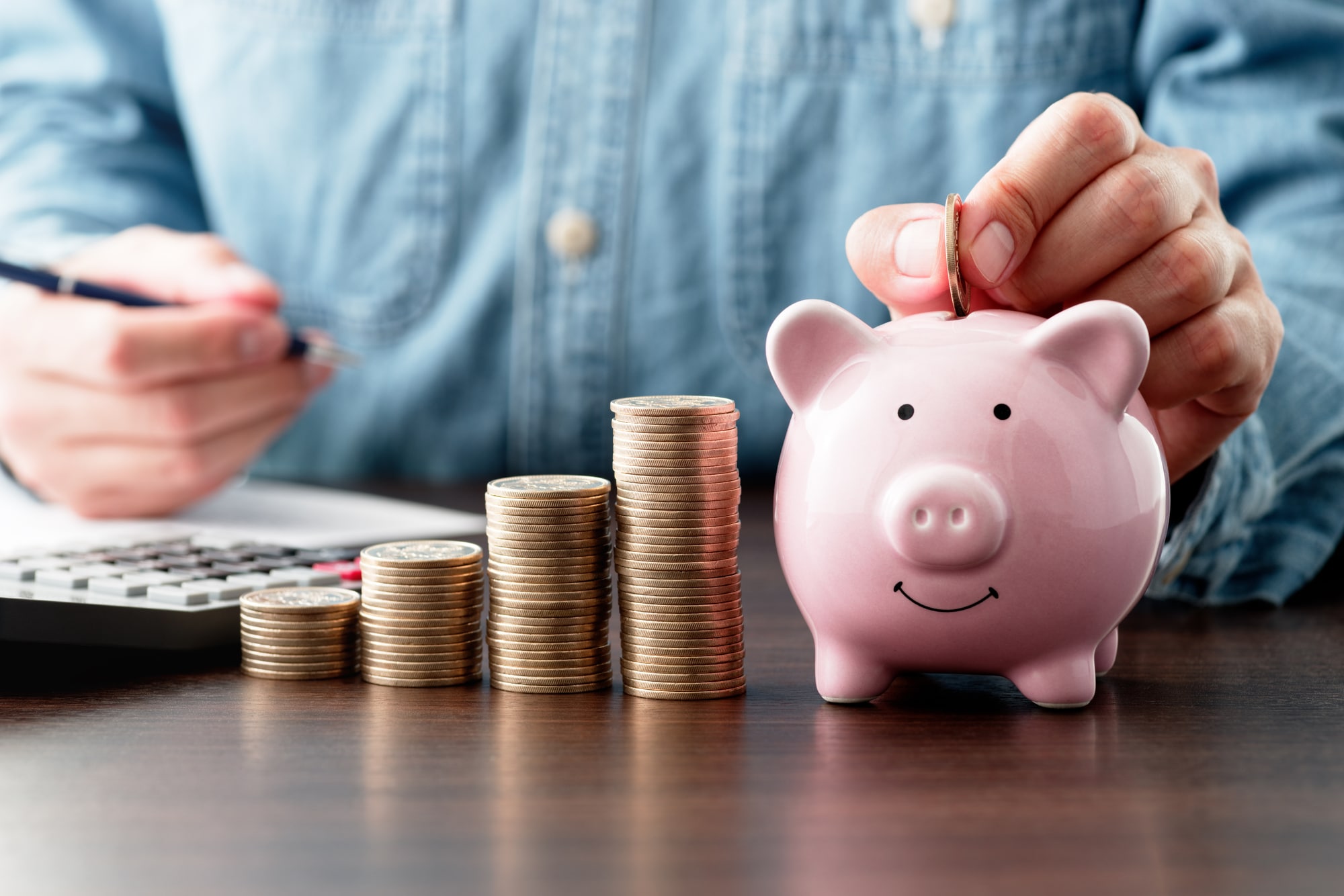 貯金箱にコインを入れる人の手元