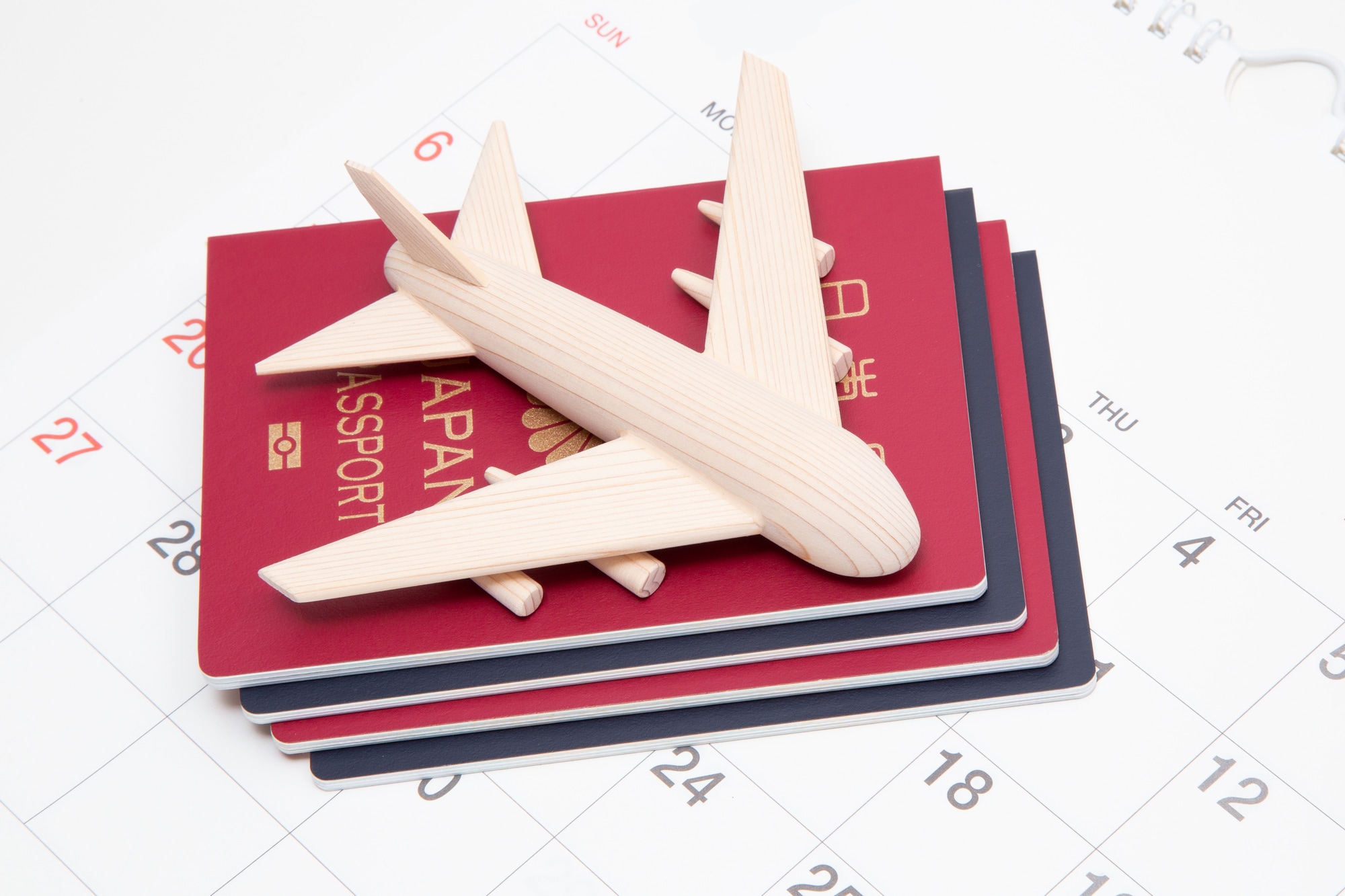 パスポートと飛行機の模型とカレンダー