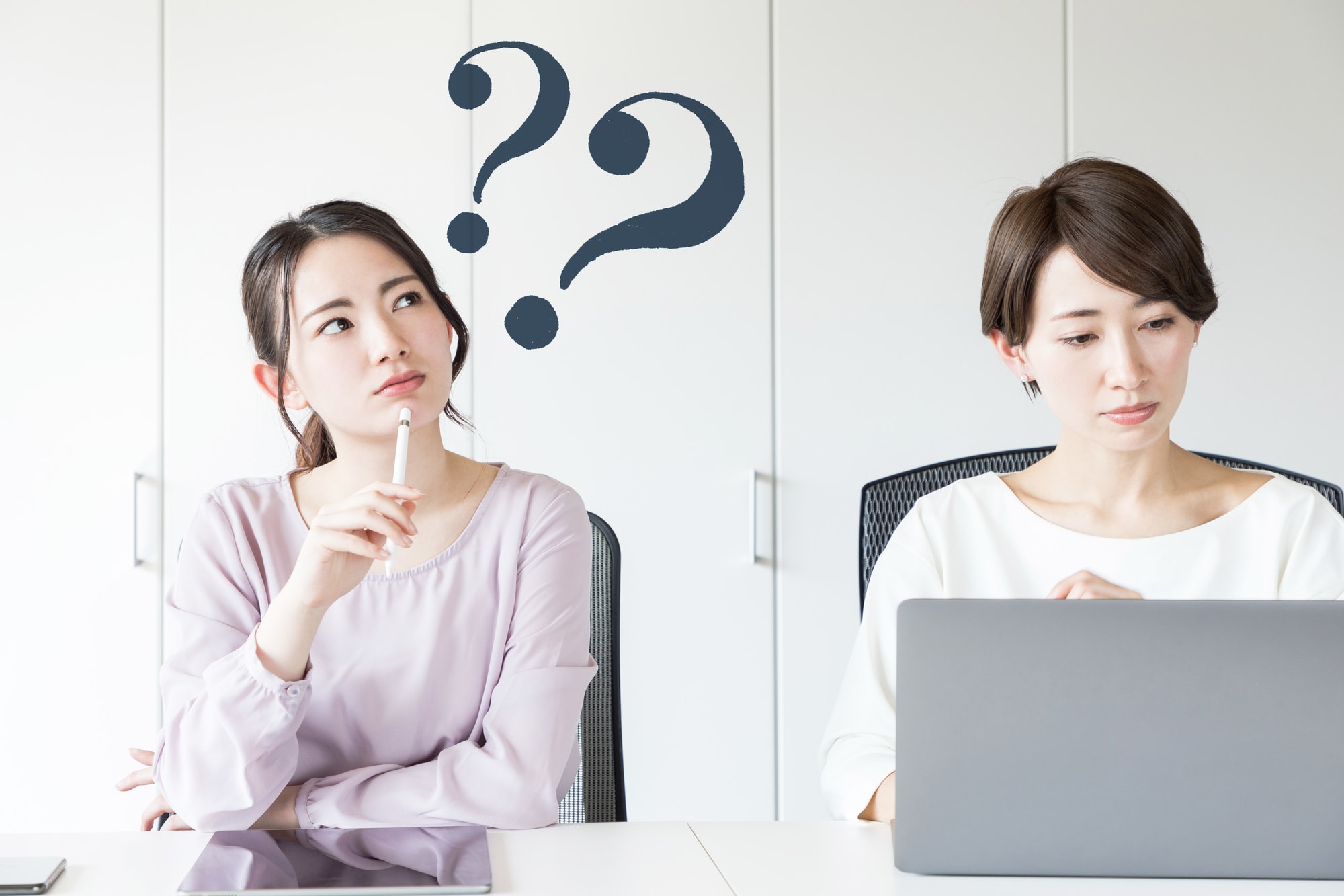 疑問を持つ女性とクエスチョンマーク