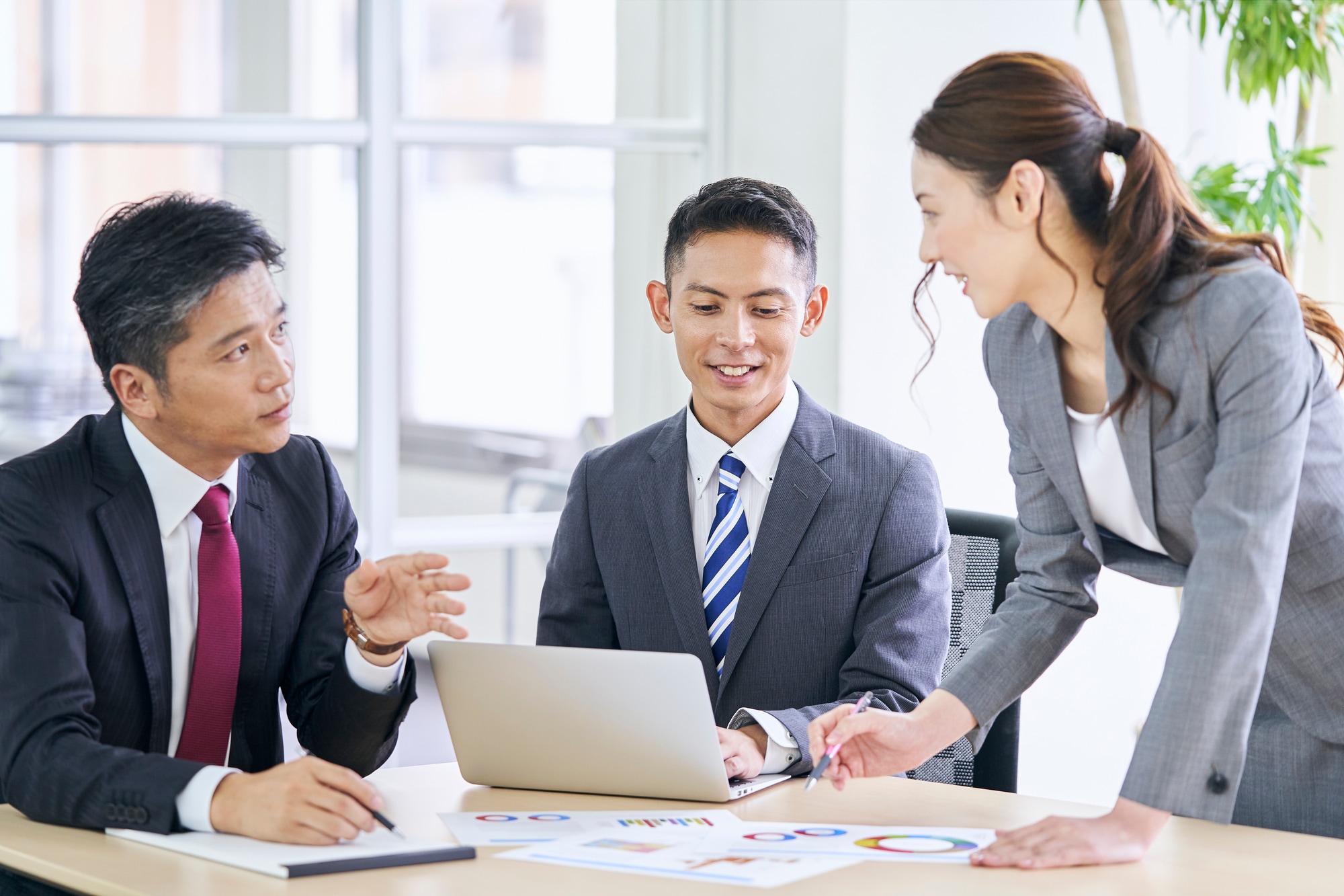 オフィスでスーツの男女がミーティング