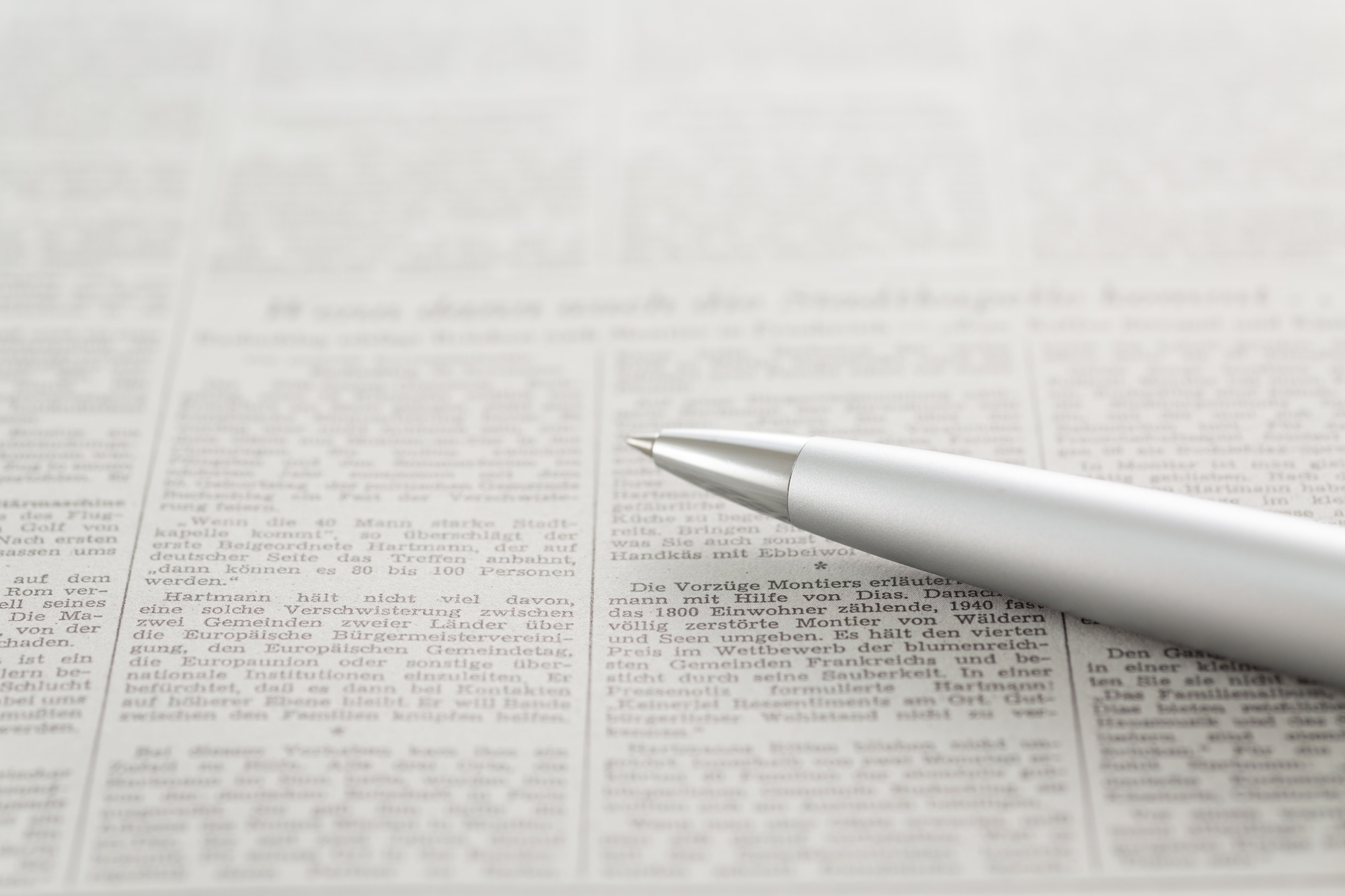 英字で書かれた書類の上に置かれたペン