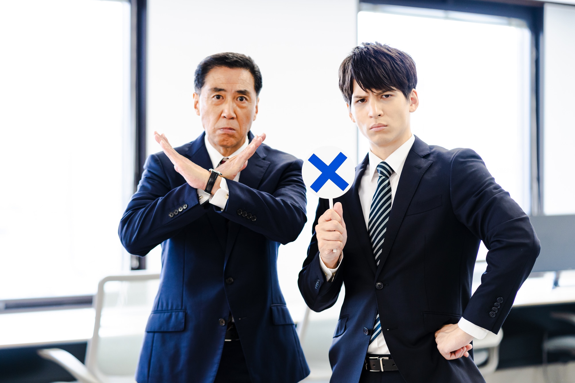 バツ印を示す2人の男性社員