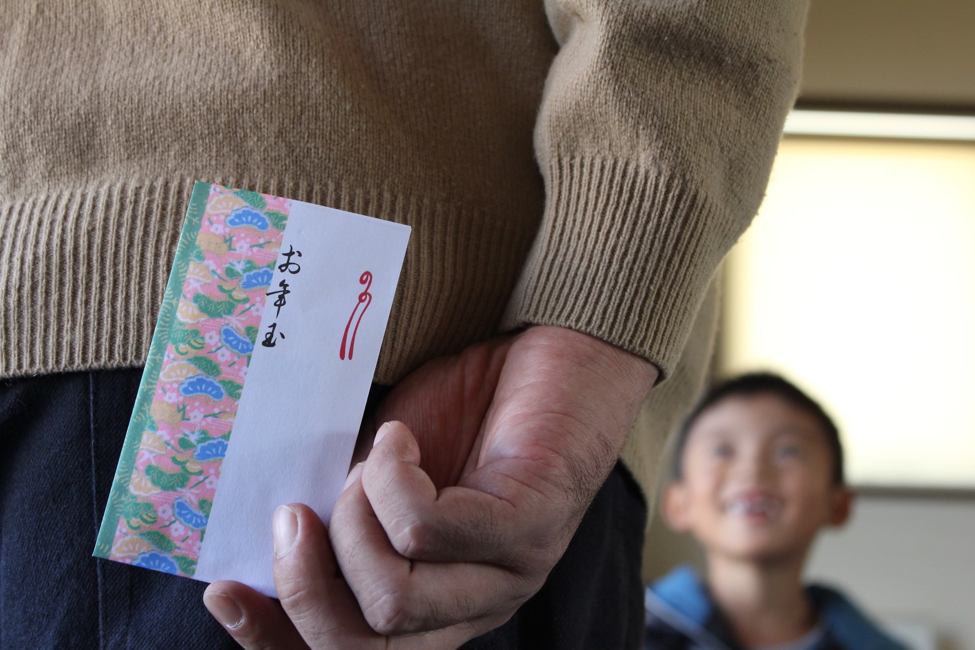 孫の前でお年玉を後ろに持つ手元