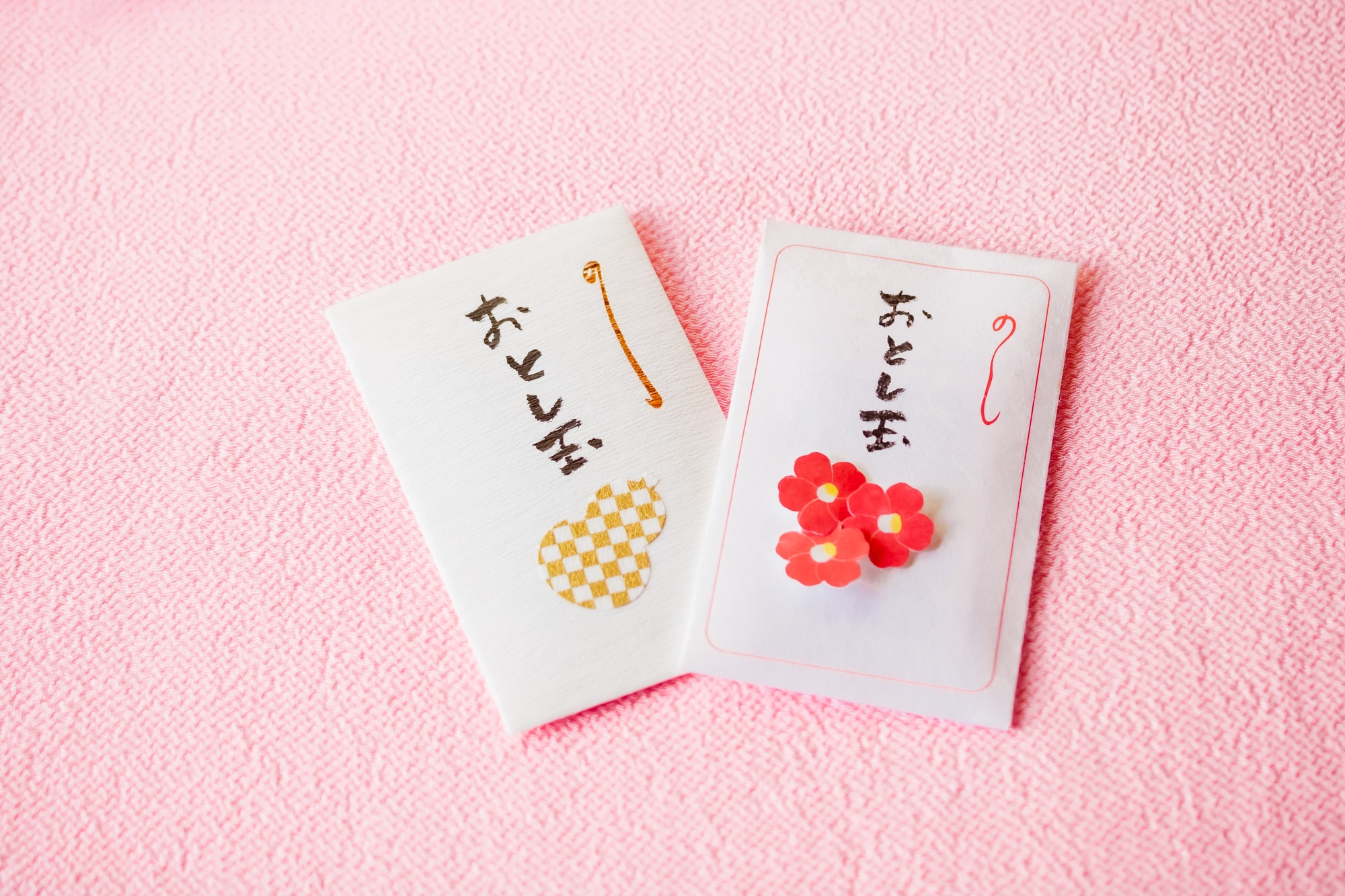 ピンクの布の上に置かれたポチ袋